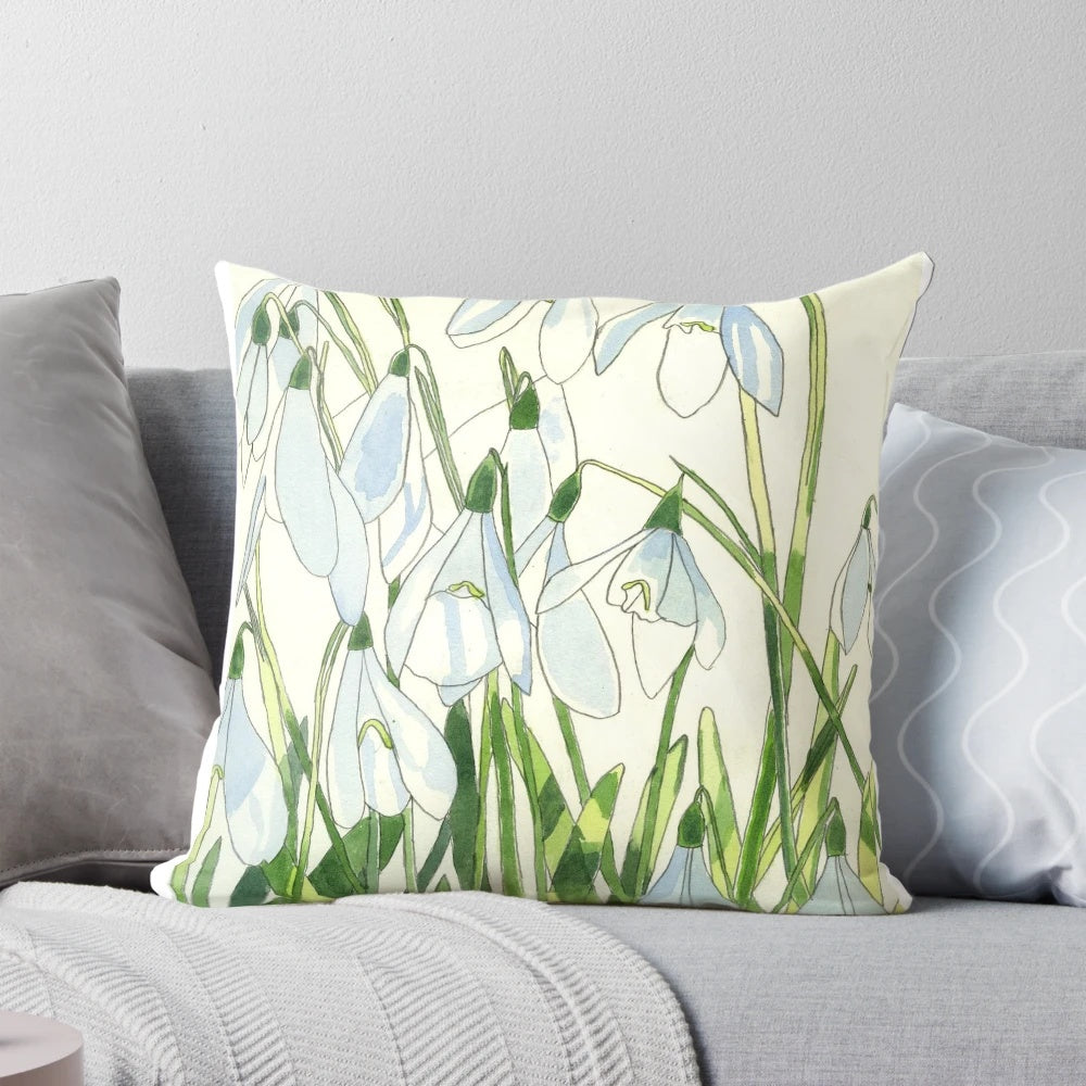 Soft, white snowdrops watercolor painting on a decorative throw pillow