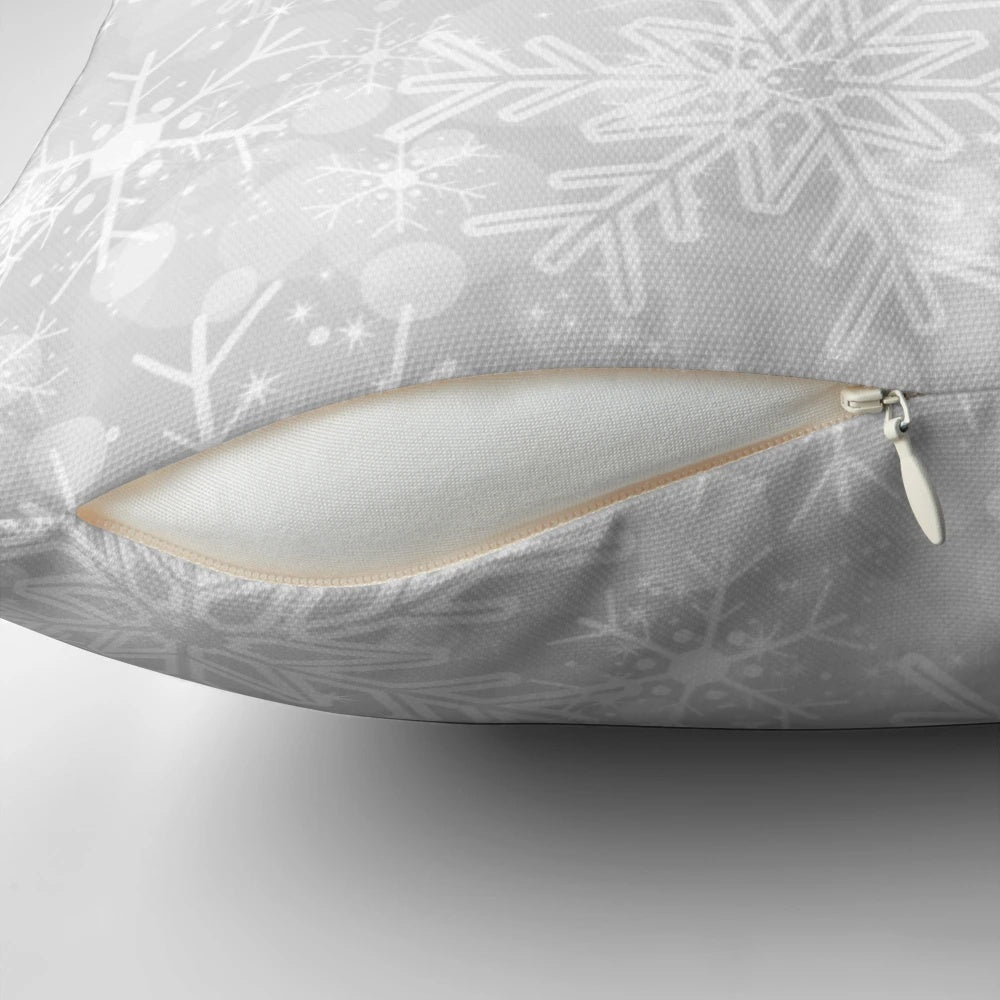 A modern, silver snowflake pattern decorative pillow for winter and holiday home decor.