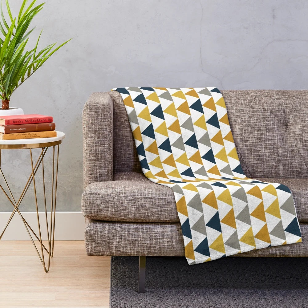 Geometric pattern plush blanket in mustard yellow, dark blue, and gray colors