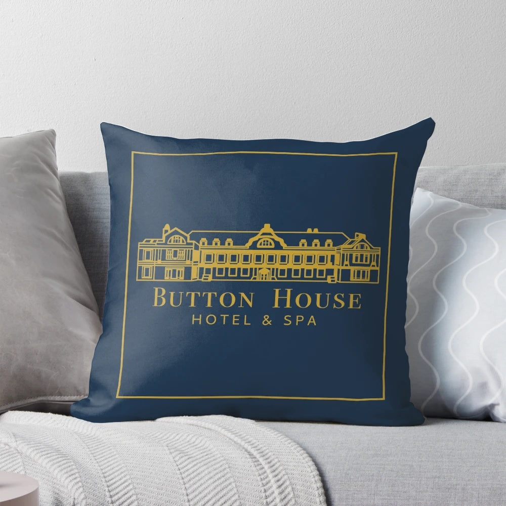 Pillow with Button House Hotel and Spa logo, featuring ghosts and haunted house elements