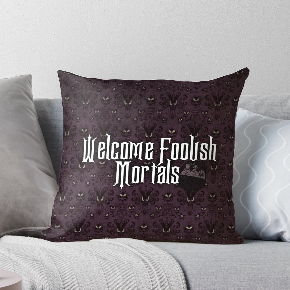 A cozy pillow featuring the "Welcome Foolish Mortals" text from the Haunted Mansion ride at Disney parks.