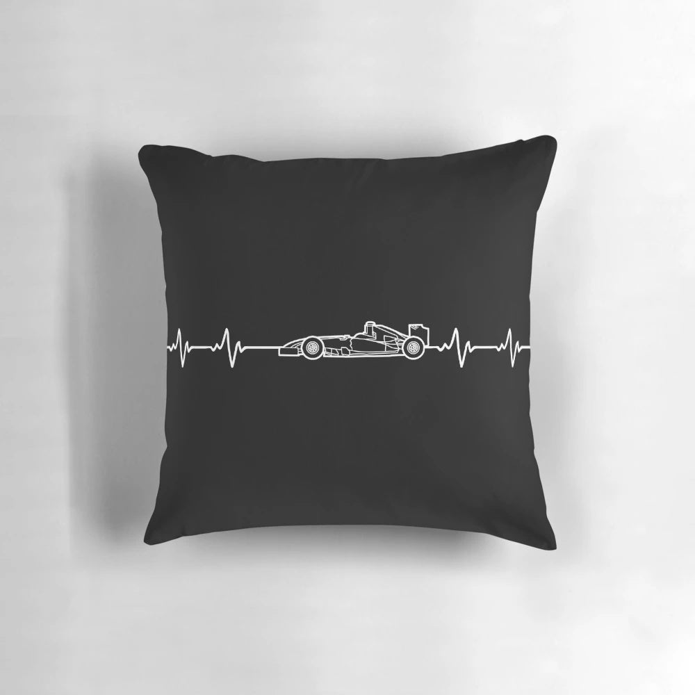 A dark-colored pillow featuring the heartbeat design of a Formula 1 racing car.