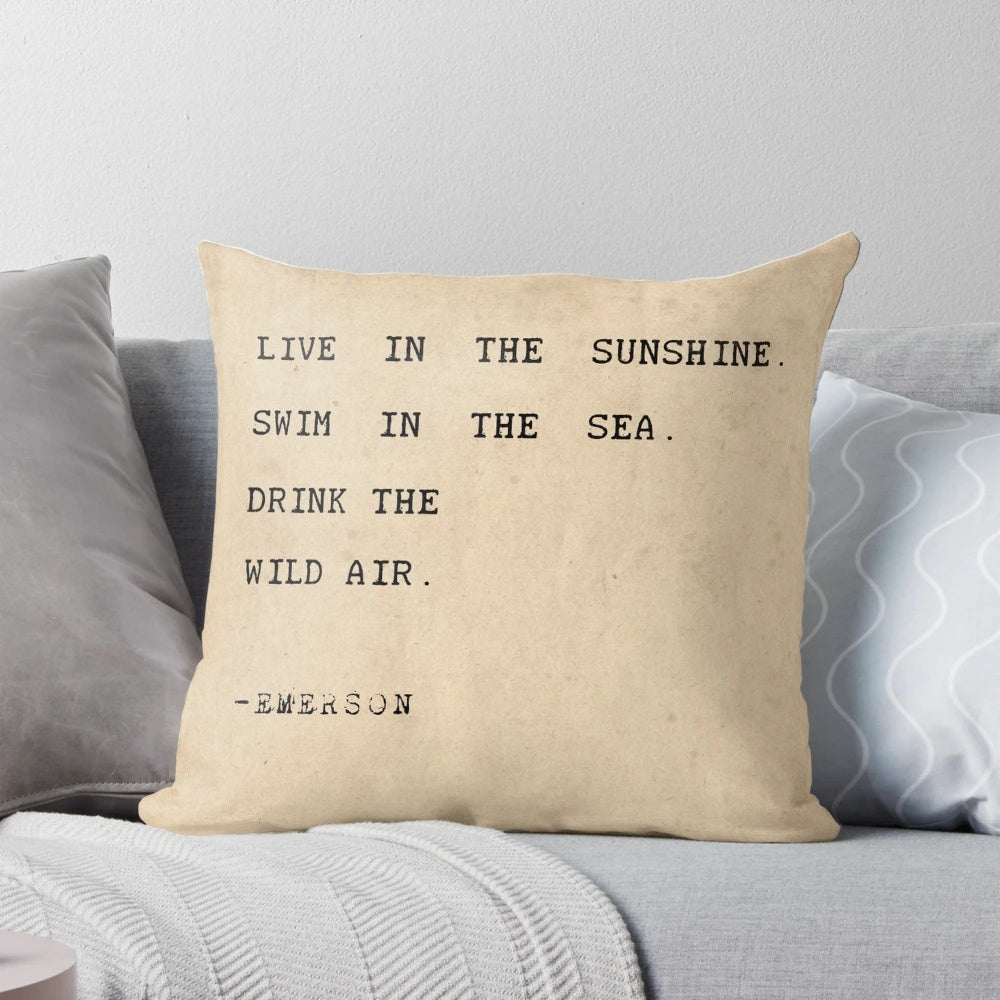 Pillow with inspirational typography quote "Live in the sunshine, swim in the sea, drink the wild air" in minimalist design
