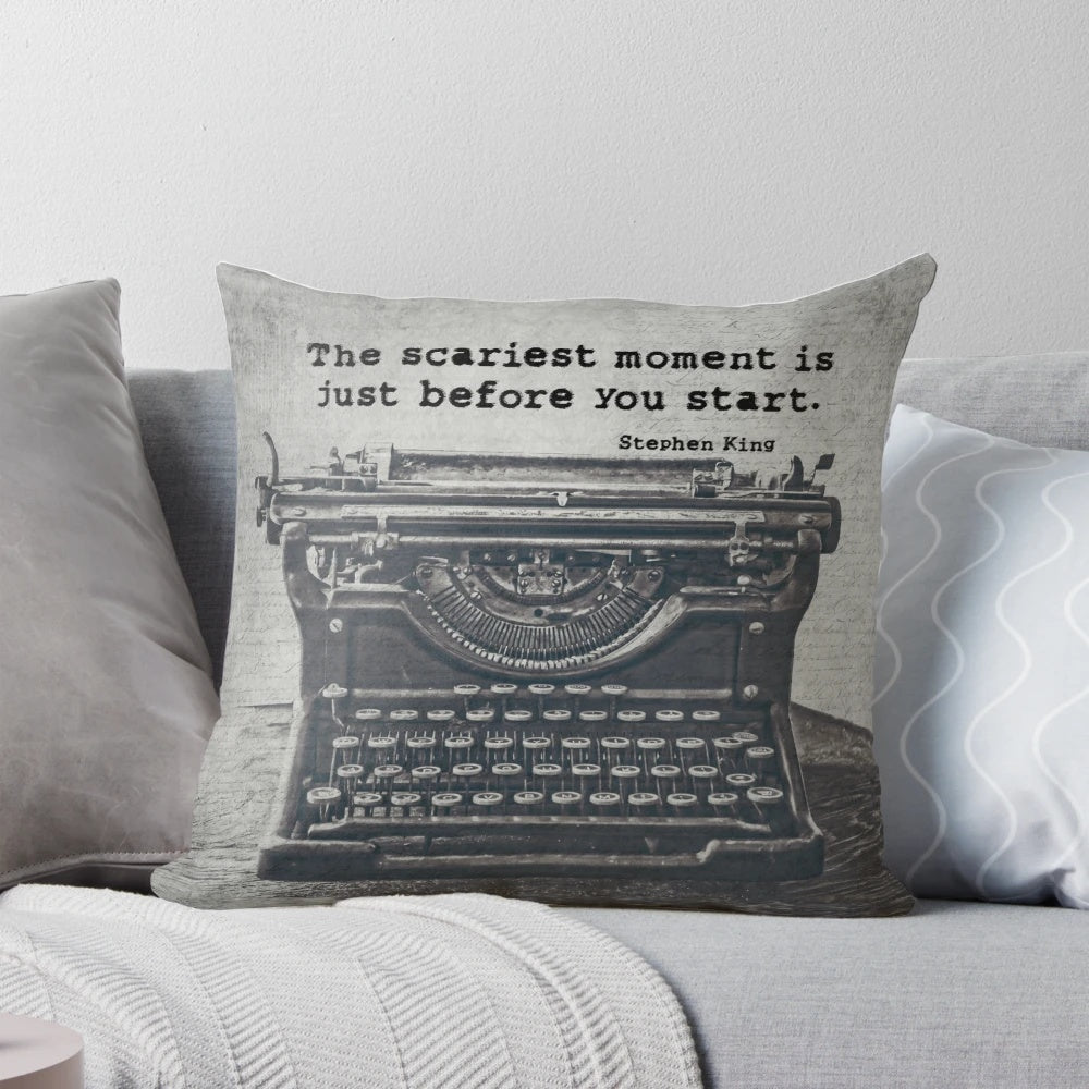A black and white pillow featuring a vintage typewriter and an inspirational quote about writing by author Stephen King