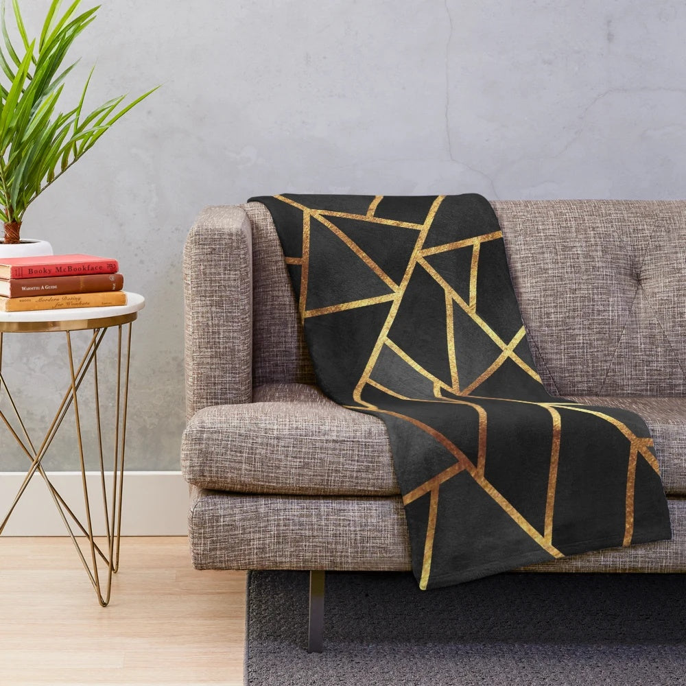 Black and gold geometric plush blanket with abstract marble pattern