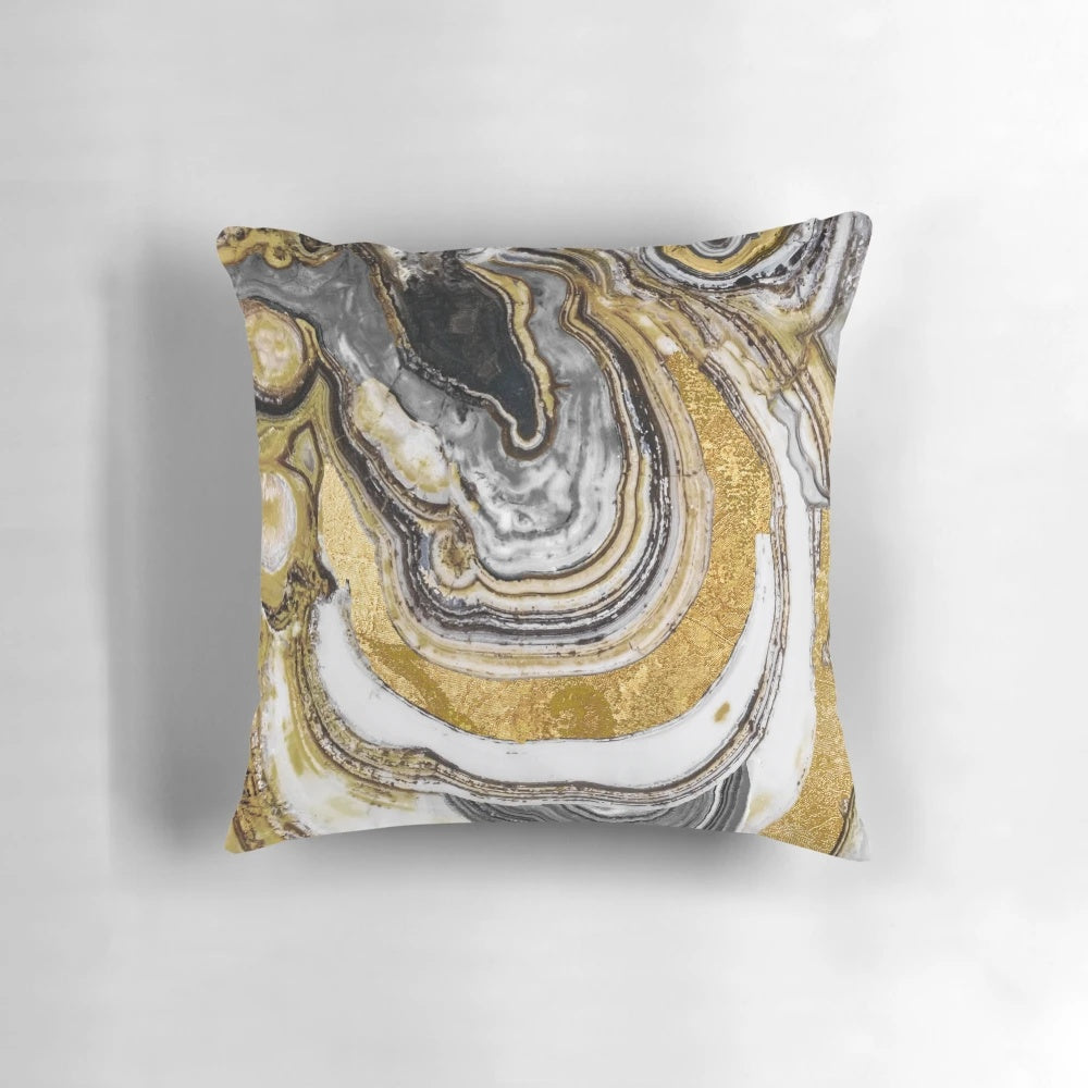 Close-up of a gold and black natural geode stone on a decorative pillow