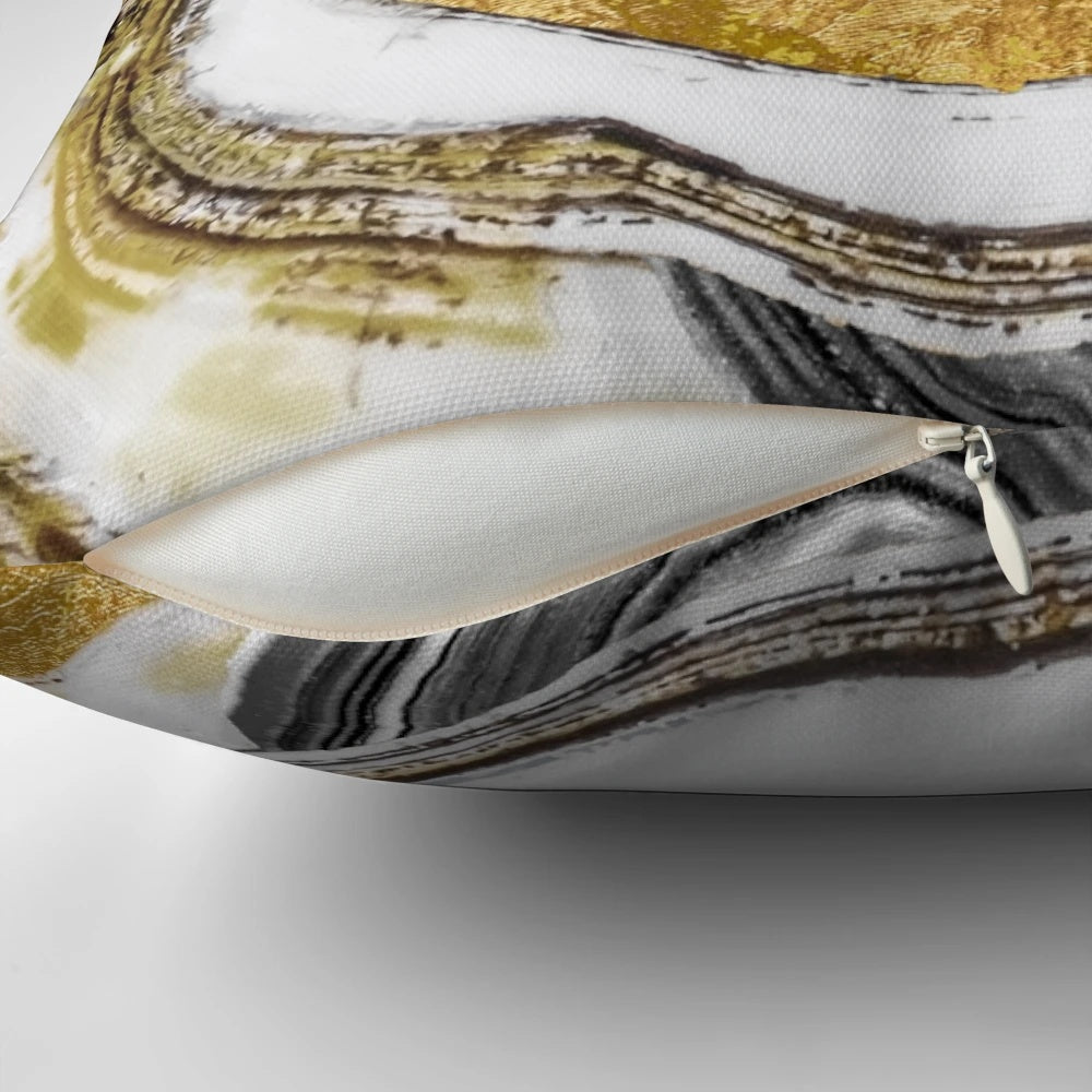 Close-up of a gold and black natural geode stone on a decorative pillow