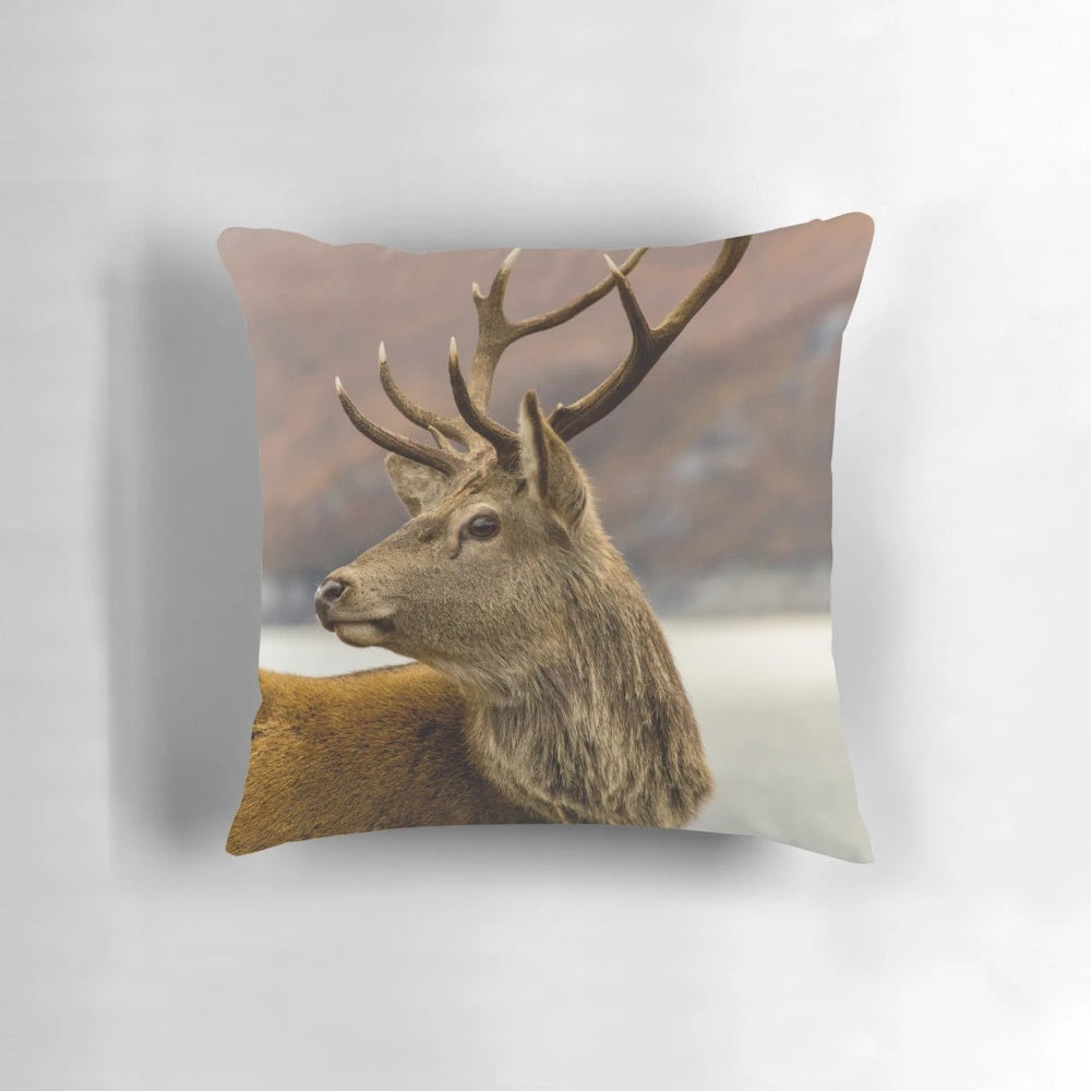A cozy pillow featuring a stunning red deer stag in the Scottish Highlands