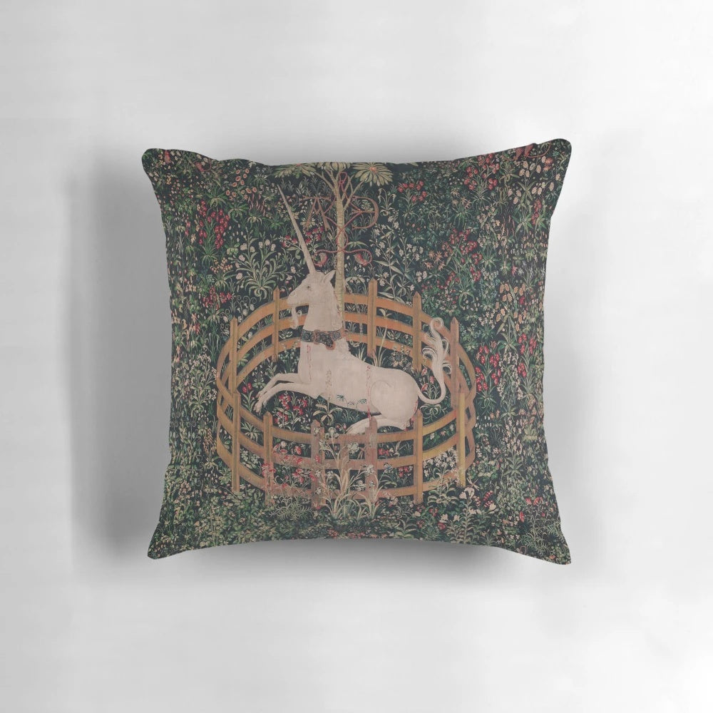 A decorative throw pillow featuring a magical unicorn in a medieval, renaissance-style floral landscape.