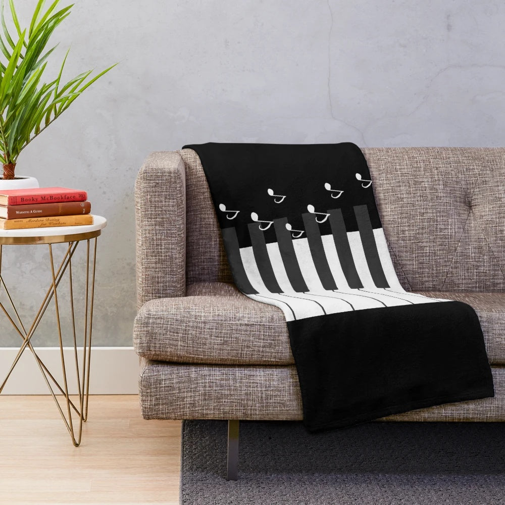 Plush blanket featuring piano keys and music notes design, perfect for music lovers