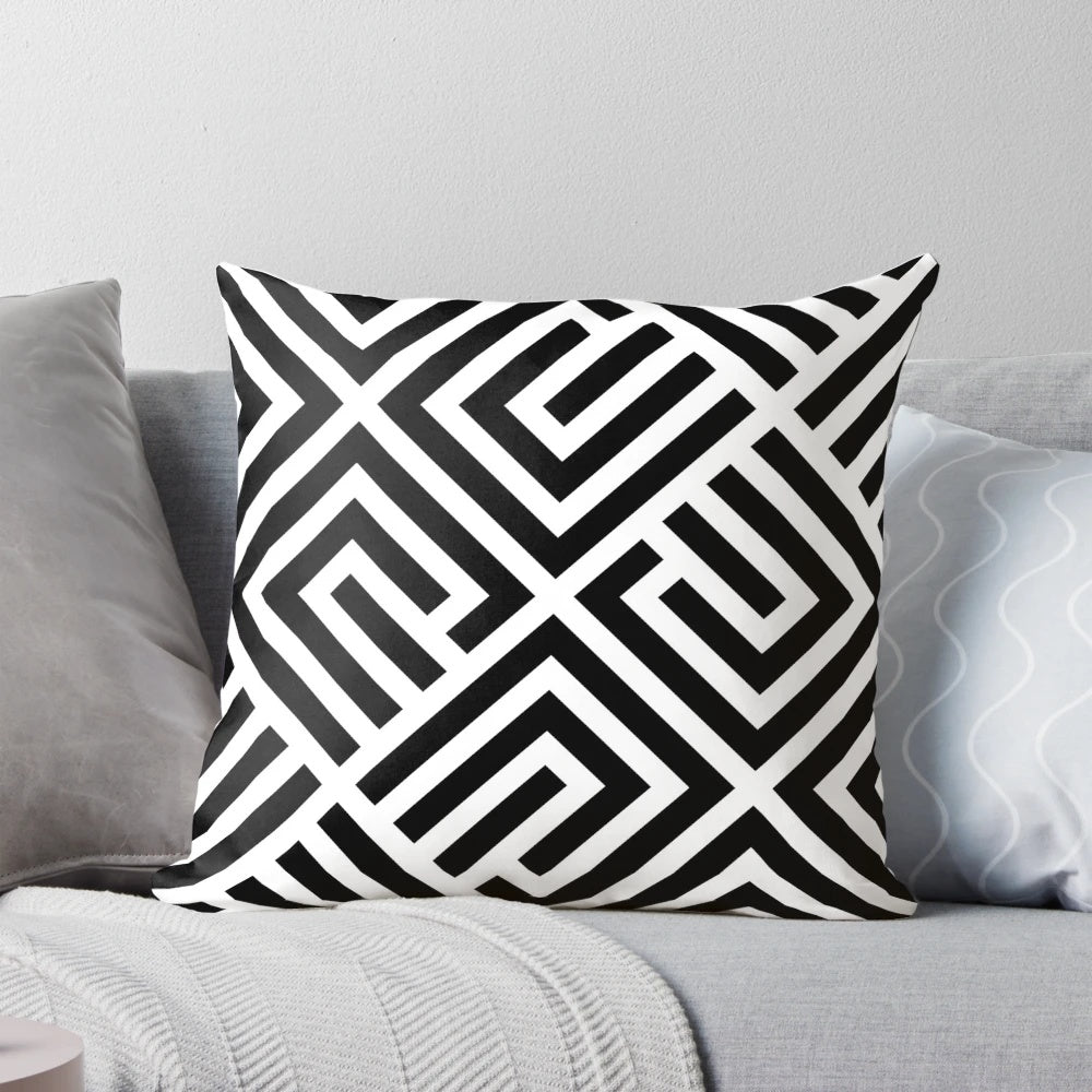 A square throw pillow featuring a geometric labyrinth pattern in black and white.