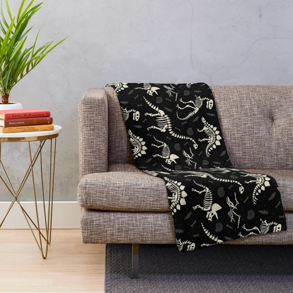 Soft, cozy black and white plush blanket featuring a dinosaur fossil pattern