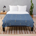Plush blanket featuring a geometric, Poseidon-inspired design in shades of blue and gold
