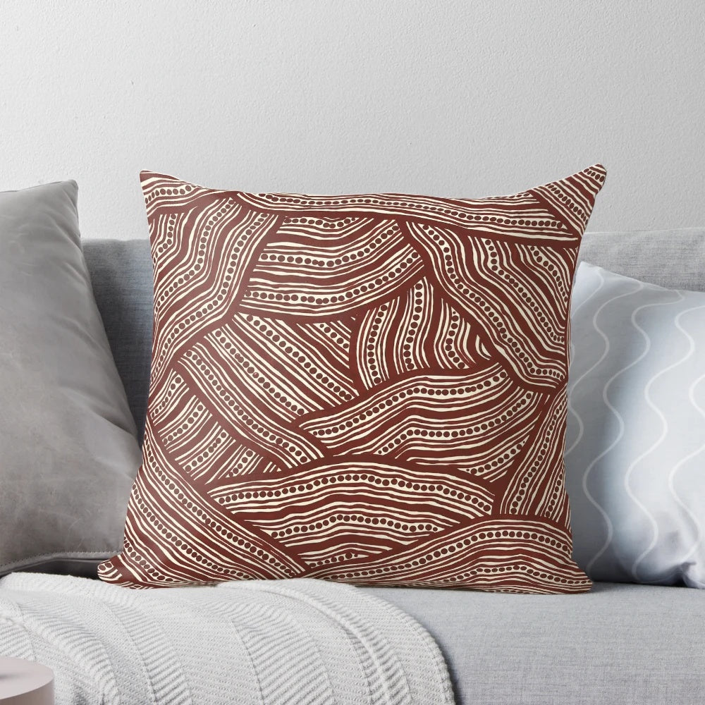 A decorative pillow with a creek bed design, inspired by Australian aboriginal art.