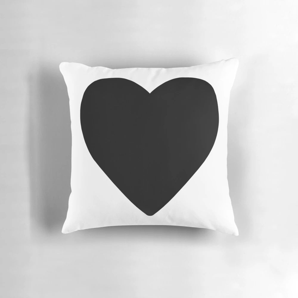 Photograph of a large black heart-shaped pillow, a cozy and enchanting addition to any living space.