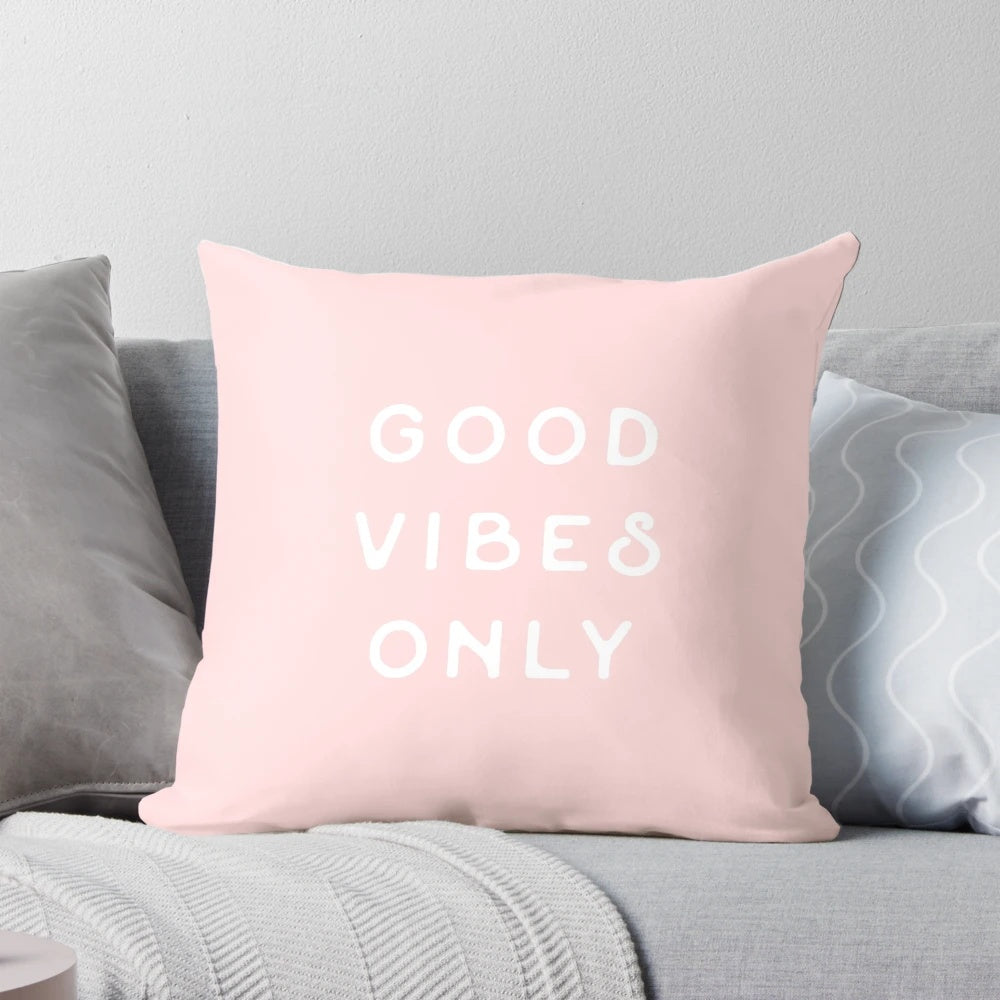 Pastel pink and blush colored pillow with small text, evoking a minimalist, California desert aesthetic.