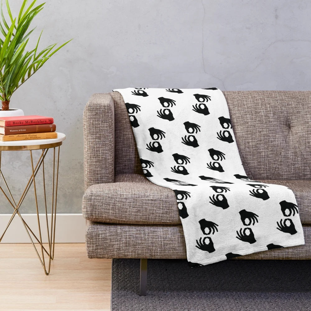 Plush blanket with black and white image of ASL interpreter hand symbols