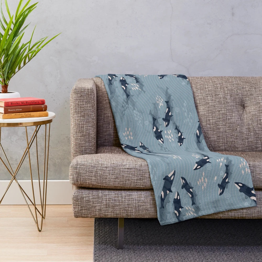 Plush blanket with a watercolor orca and ocean waves design