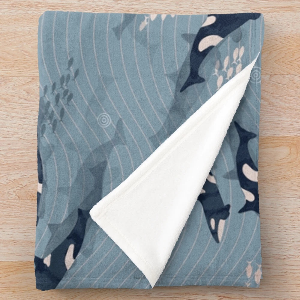 Plush blanket with a watercolor orca and ocean waves design