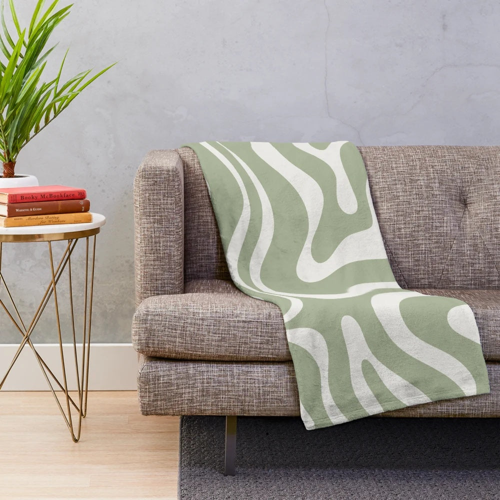 Sage green and white plush blanket featuring an abstract swirl pattern