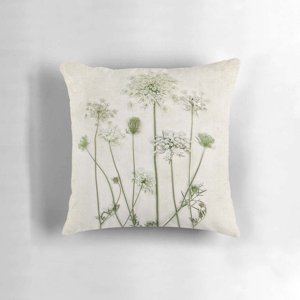 A beautiful Queen Anne's lace flower featured on a white and green minimalist pillow.