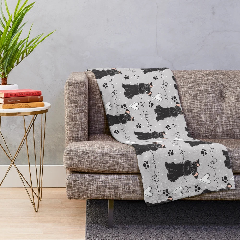 Black and white miniature schnauzer dog on a soft, plush blanket
