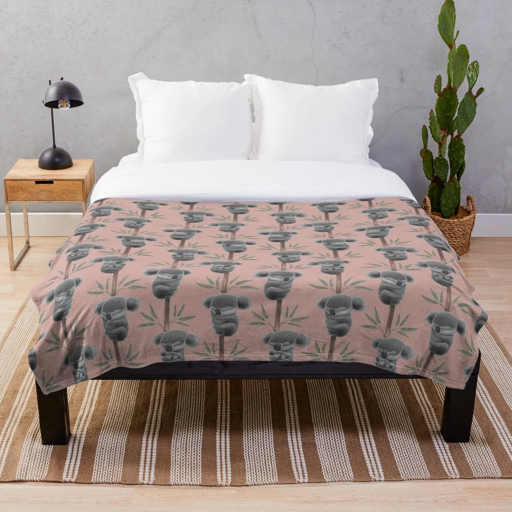 A plush blanket featuring a sleeping koala, supporting Australian wildlife conservation