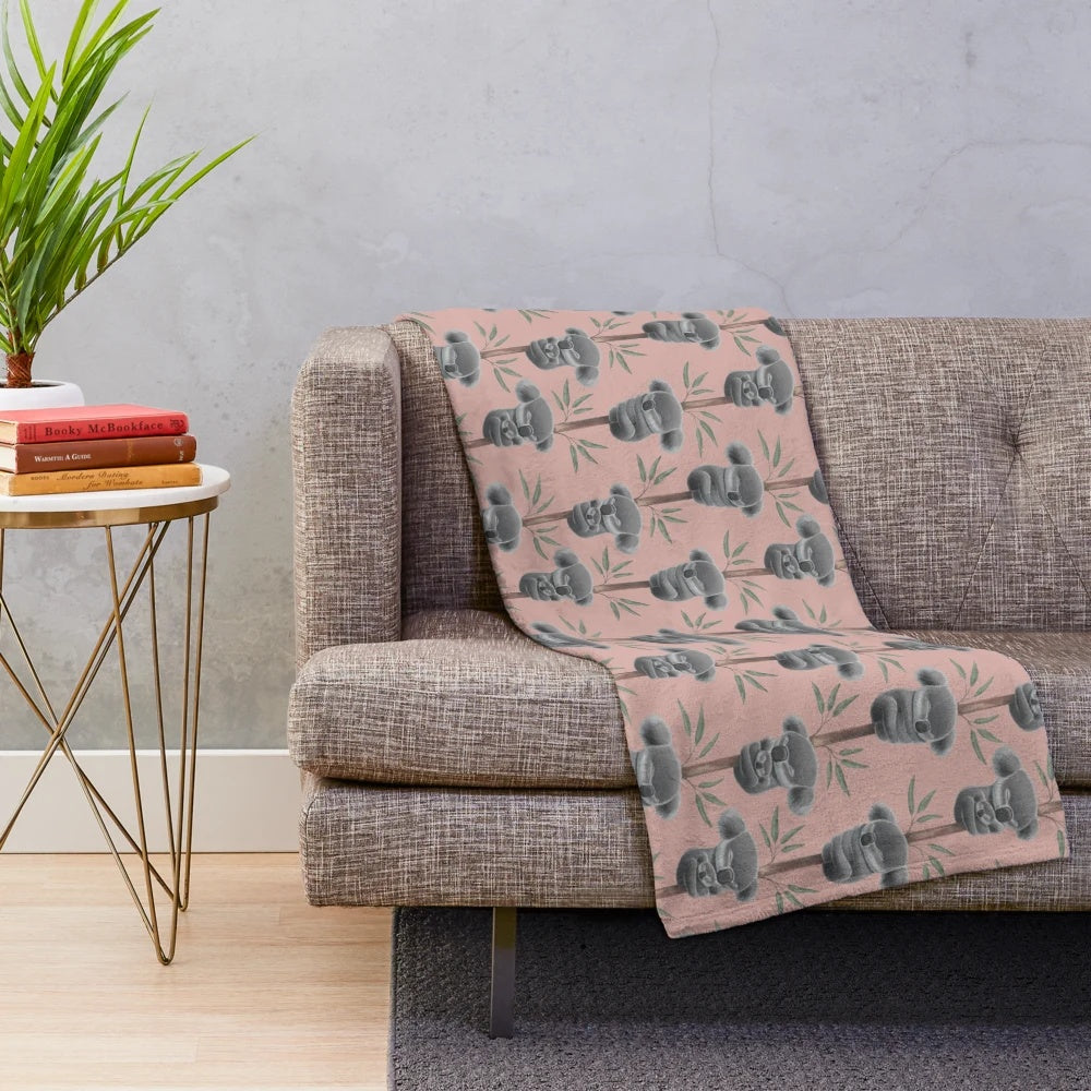 A plush blanket featuring a sleeping koala, supporting Australian wildlife conservation