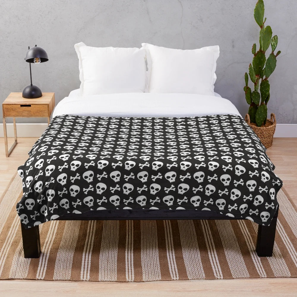 Spooky skulls and crossbones design on a black plush blanket