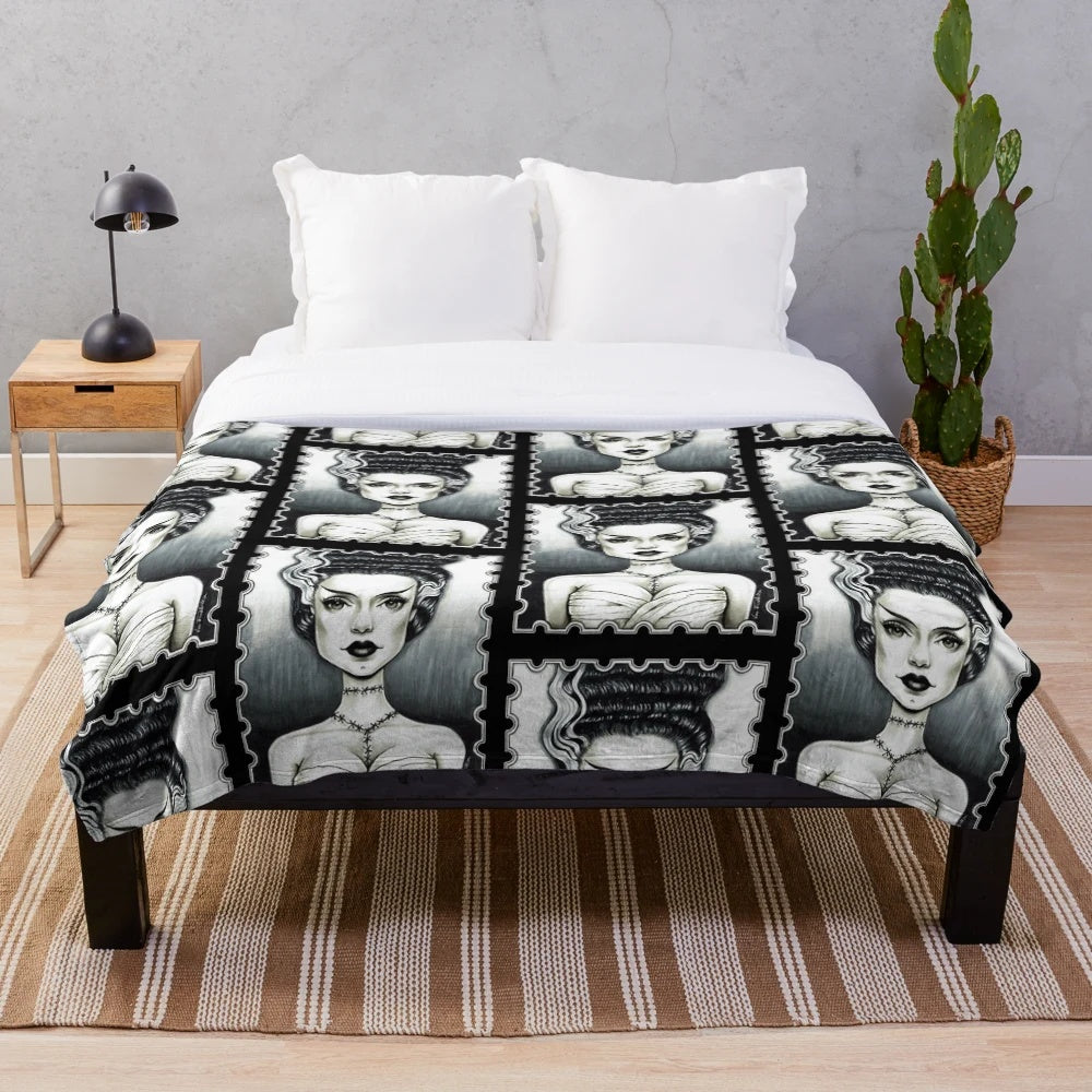 A plush blanket featuring a vintage-inspired black and white illustration of the Bride of Frankenstein character.