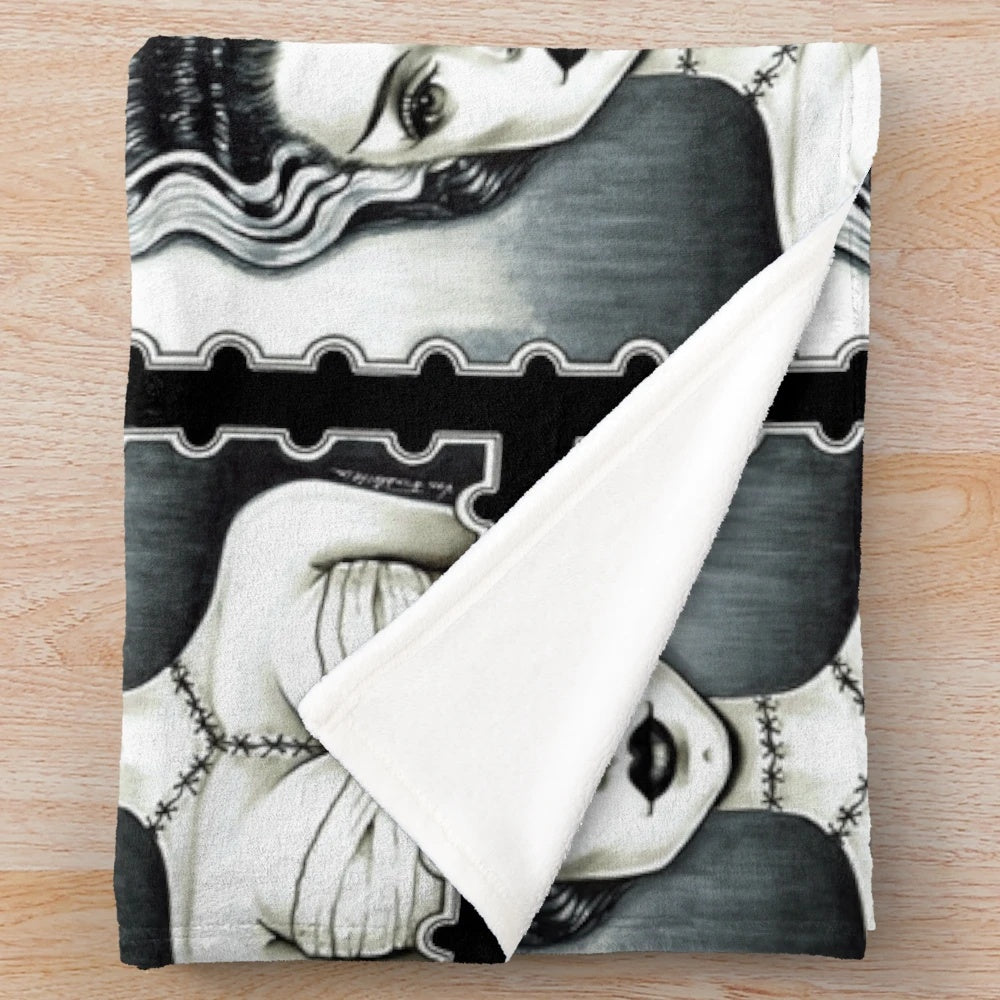 A plush blanket featuring a vintage-inspired black and white illustration of the Bride of Frankenstein character.