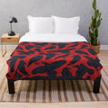 A plush blanket featuring a repeating pattern of crows or ravens in black and red
