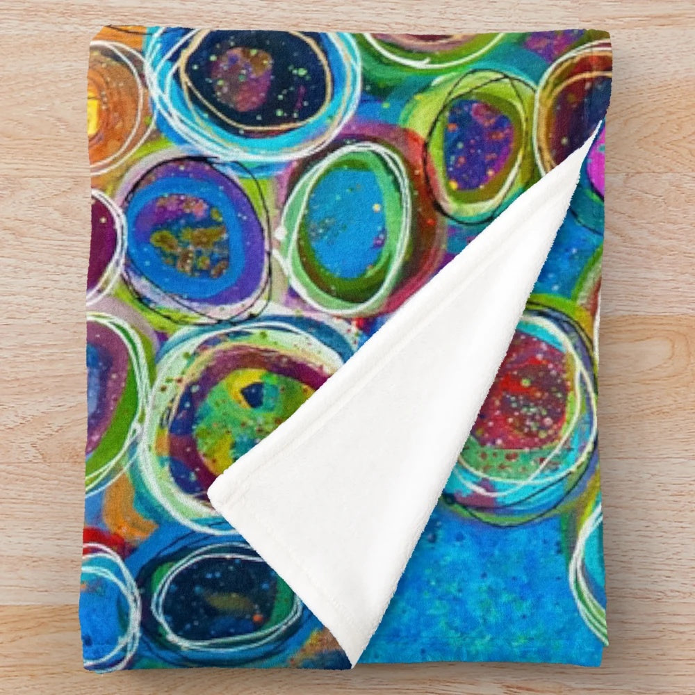 Vibrant abstract patterned plush blanket with geometric shapes and colorful design