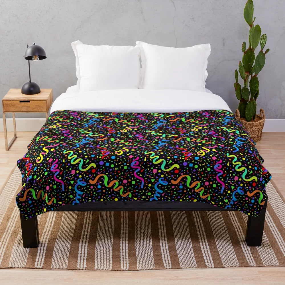 Colorful plush blanket with a retro arcade-inspired pattern of neon colors, confetti, and stars