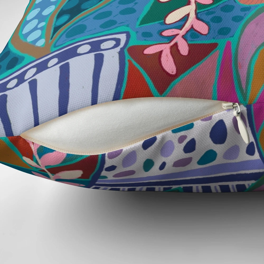 Exuberant flowers in blue, green, pink, and yellow vases printed on a decorative throw pillow.