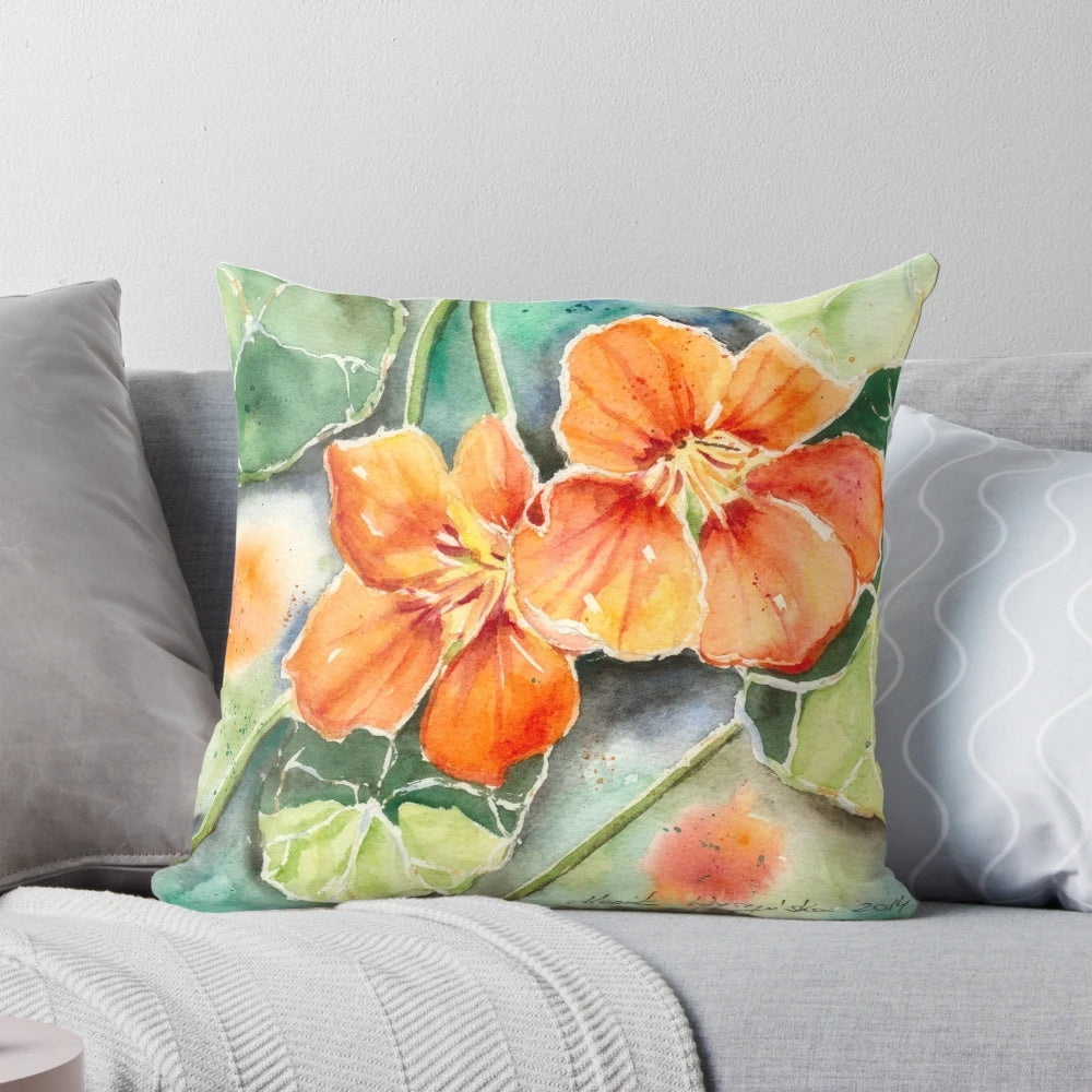 Closeup of a watercolor painting of orange nasturtium flowers on a decorative pillow.