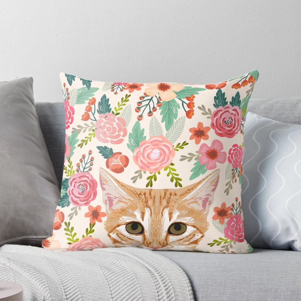 Decorative pillow featuring a vibrant floral pattern with a cute tabby cat central motif