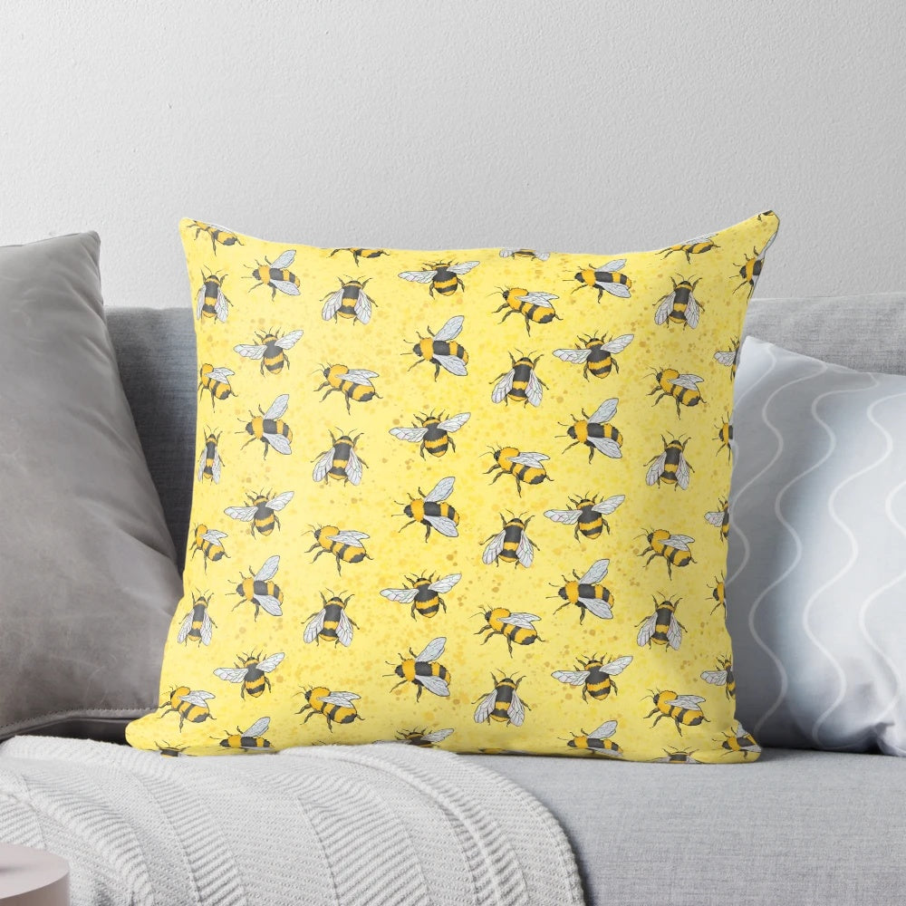 A yellow and black patterned pillow featuring a repeating bumble bee design