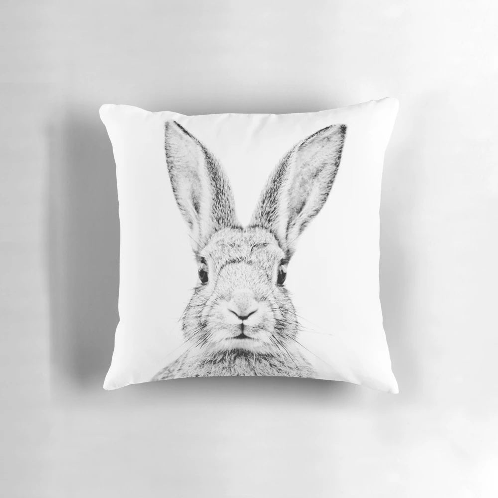 Vintage-style minimalist line drawing of a bunny on a white background, printed on a decorative pillow.