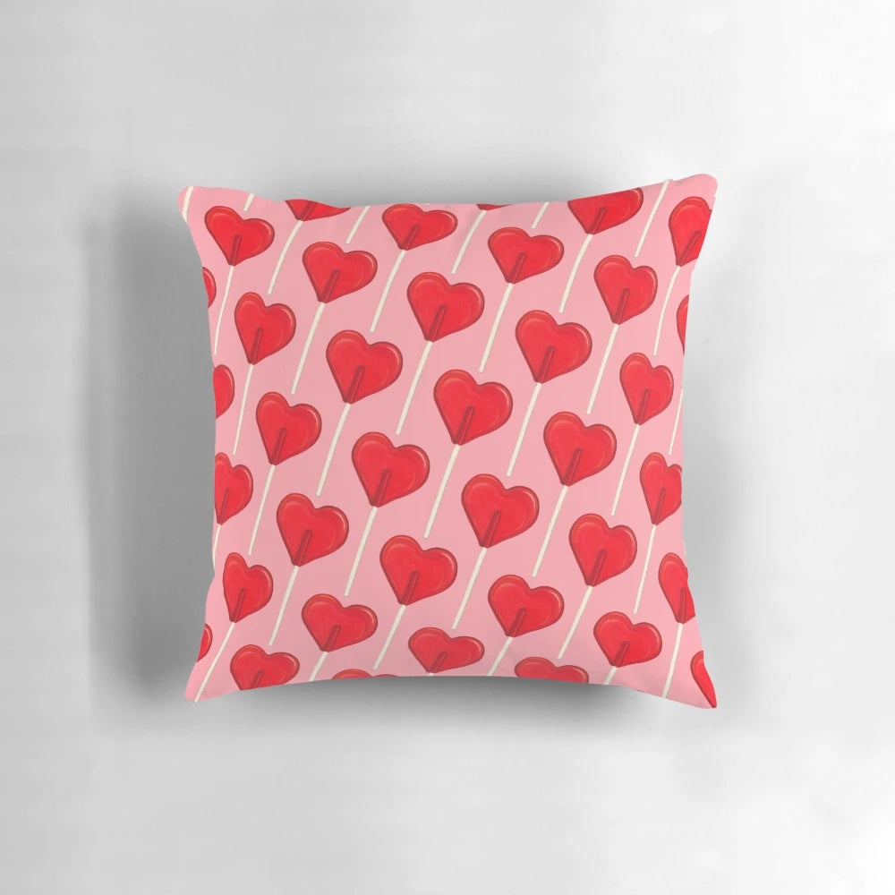 A pink, heart-shaped lollipop decorative pillow with a retro, vintage design.