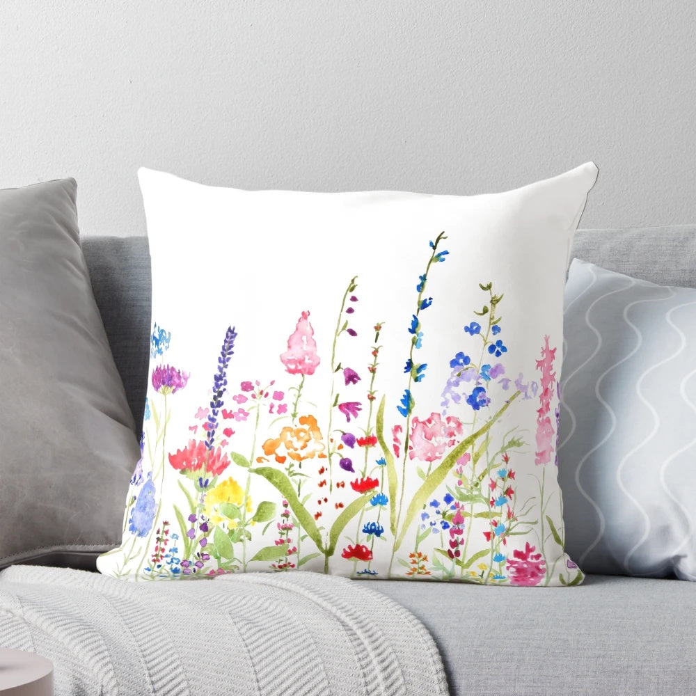A beautifully hand-painted pillow featuring a vibrant field of colorful wild flowers, perfect for adding a touch of natural charm to any space.
