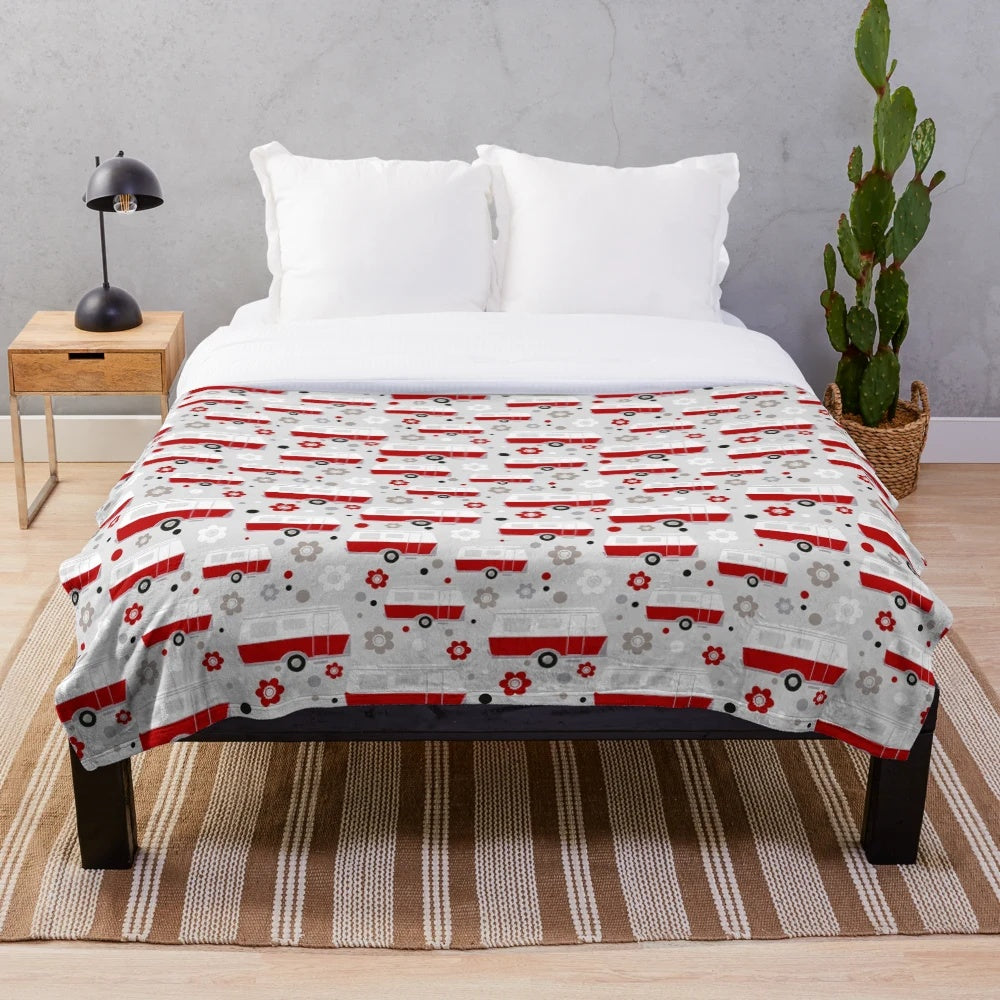Vintage caravan-inspired plush blanket in red, white, and grey colors with a repeat pattern design
