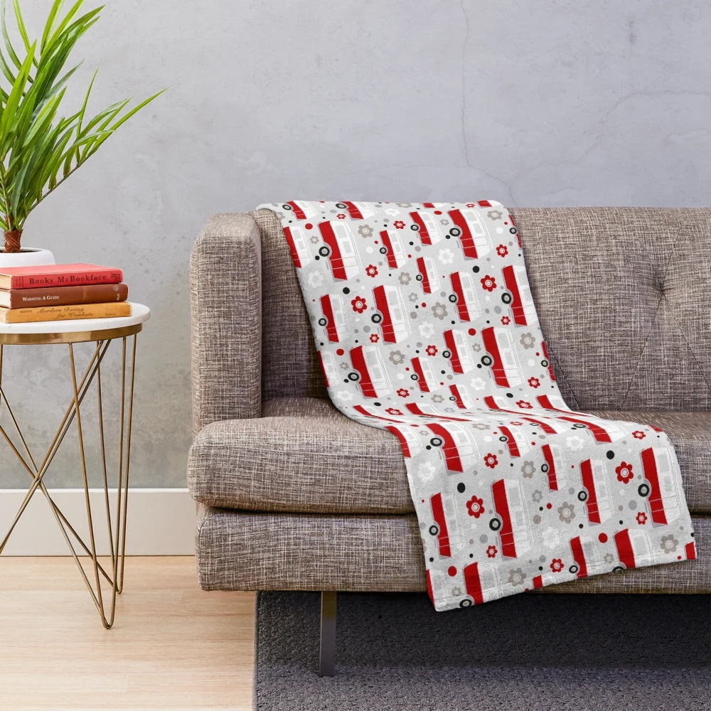 Vintage caravan-inspired plush blanket in red, white, and grey colors with a repeat pattern design
