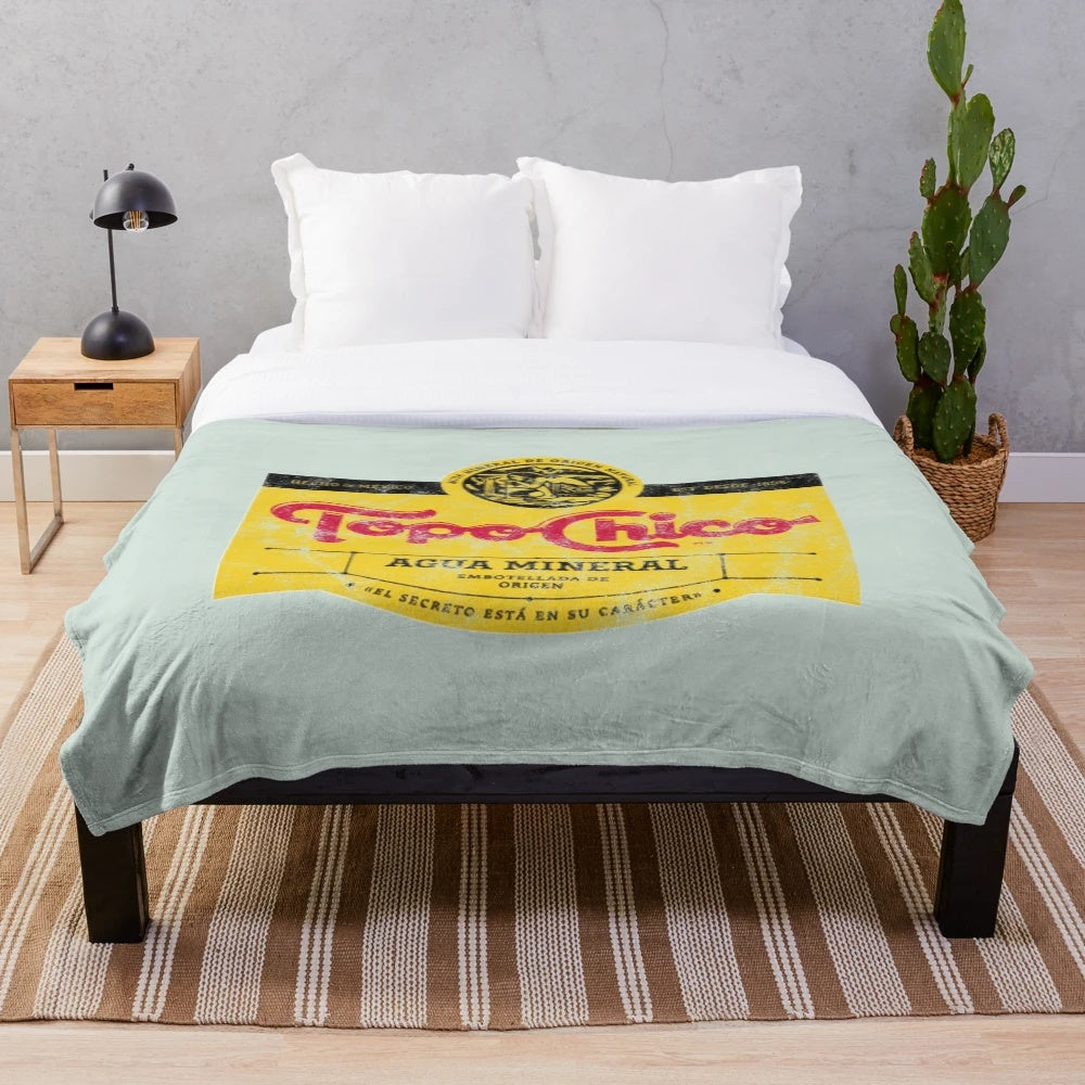 Topo Chico mineral water-inspired plush blanket with a worn, vintage design