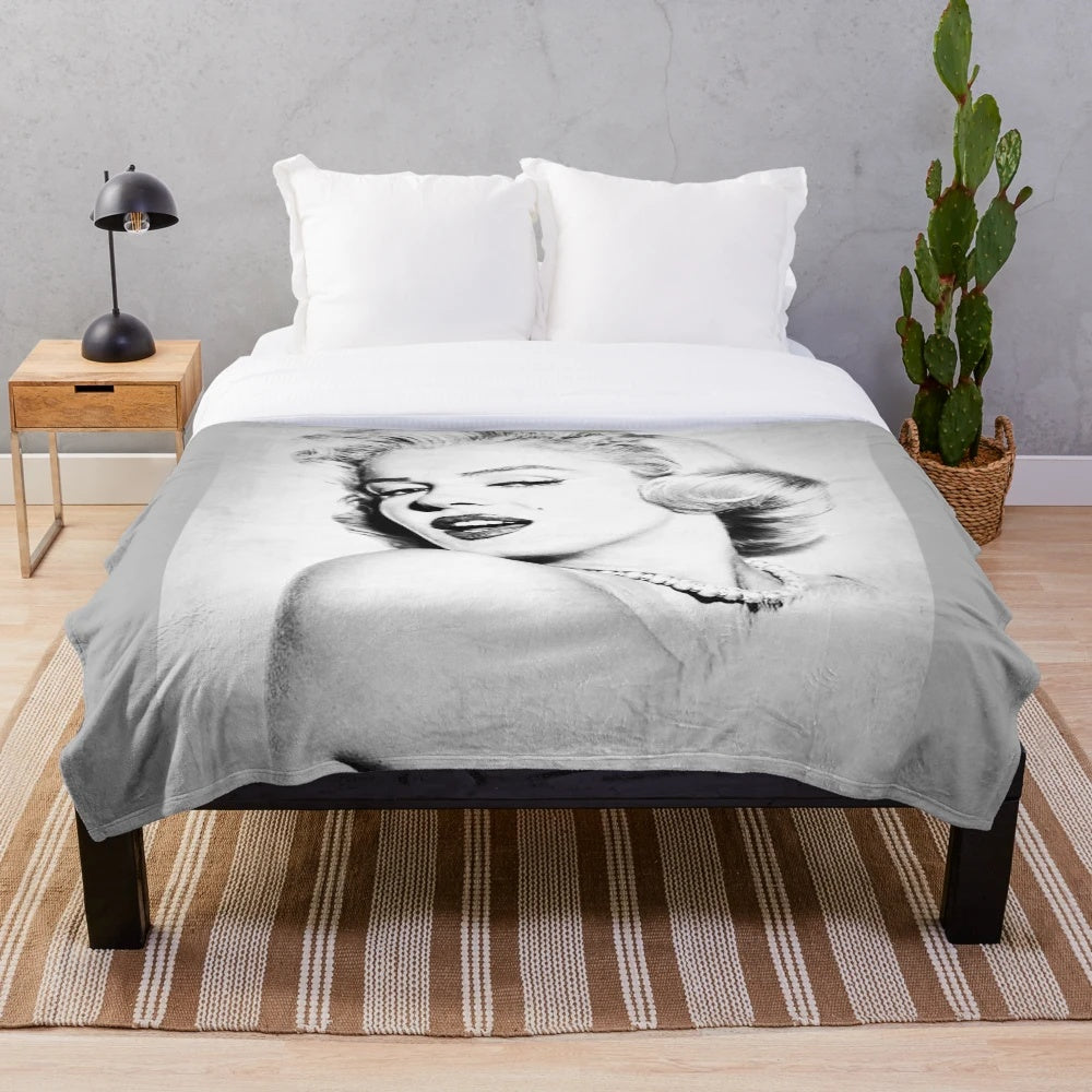 Vintage black and white portrait of Marilyn Monroe on a plush blanket