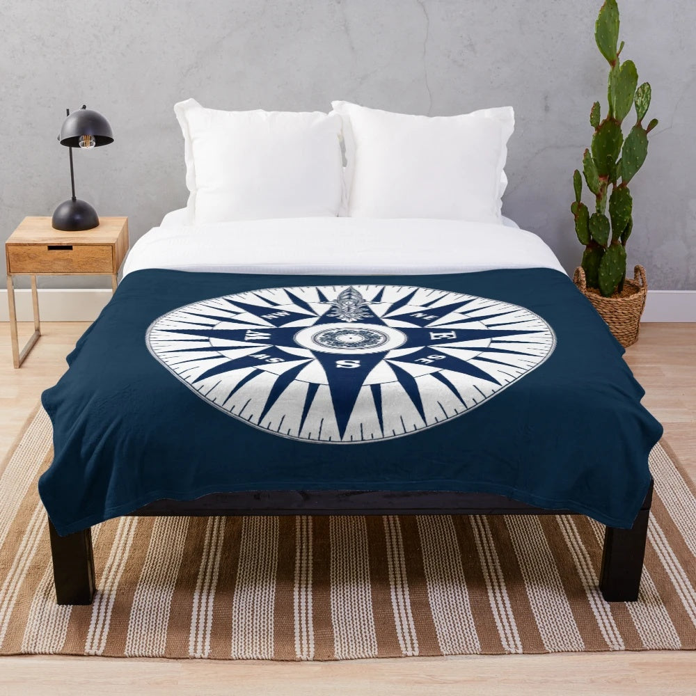 Ornate vintage nautical compass design on a navy blue plush blanket