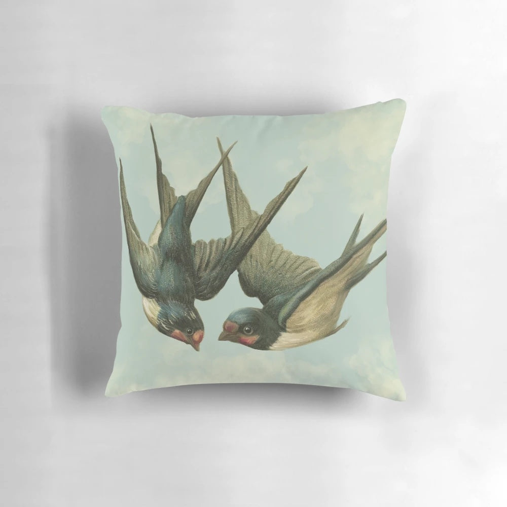 Vintage-inspired decorative pillow featuring a pair of flying swallows against a cloudy blue sky background.