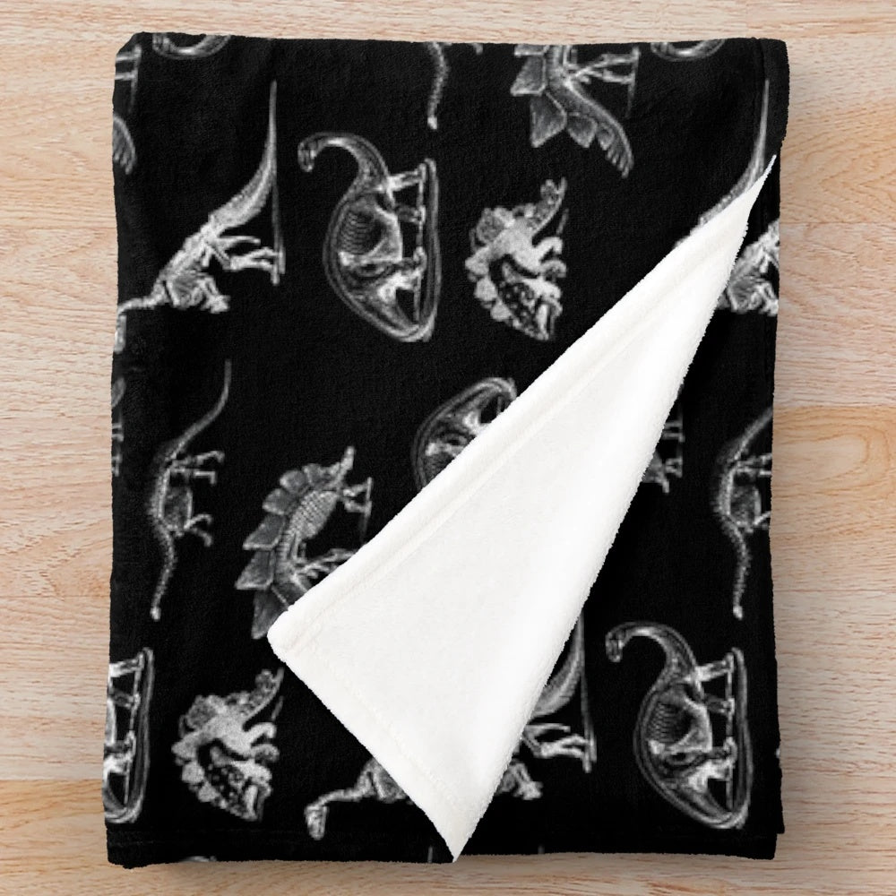 Vintage style plush blanket featuring dinosaur and skeleton x-ray designs