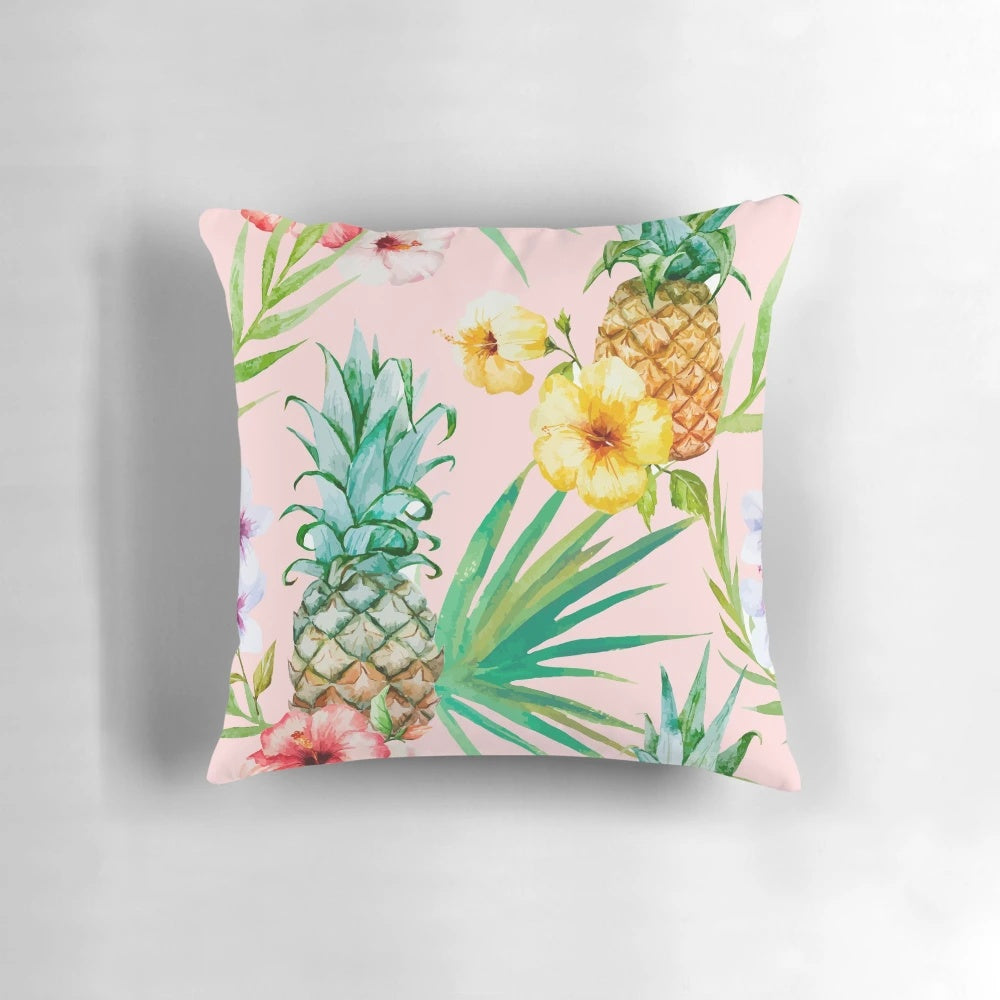 A vintage-inspired tropical botanical pillow featuring a watercolor painting of pineapples, palm leaves, and a blush color palette.