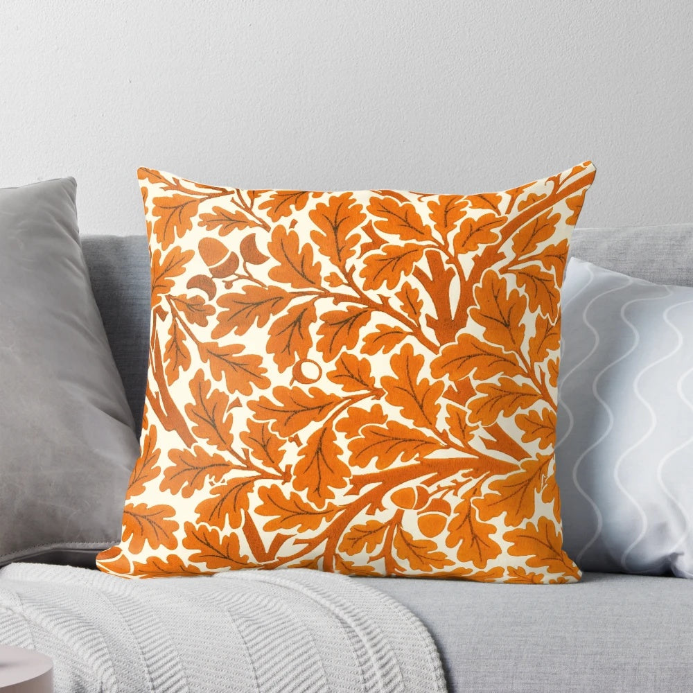 Vintage-inspired throw pillow featuring a William Morris oak leaf textile pattern in rust orange and cream colors.